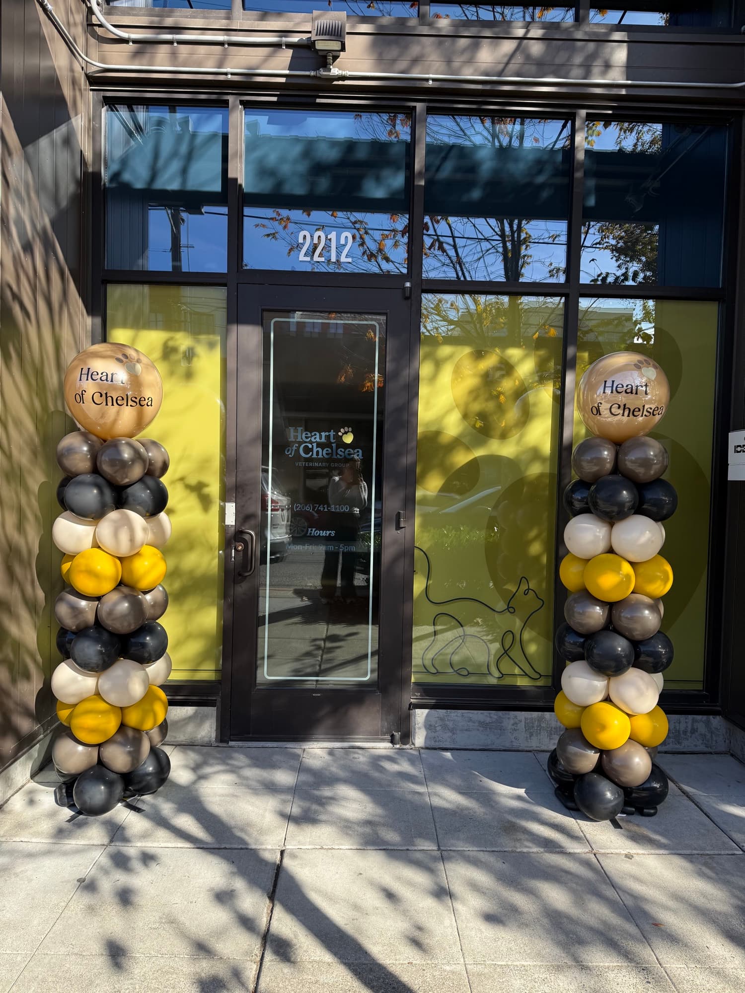 Sculpted balloon columns framing a corporate storefront activation.