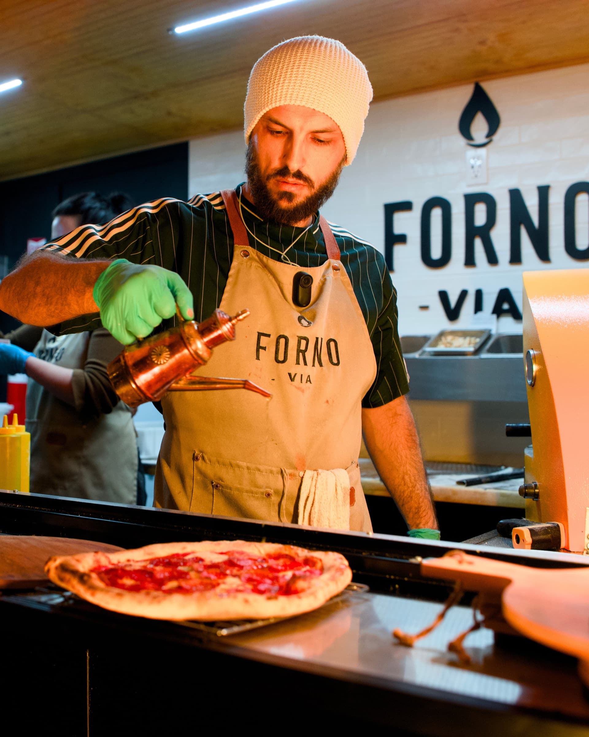 Forno Via chef preparing pizza inside the mobile trailer