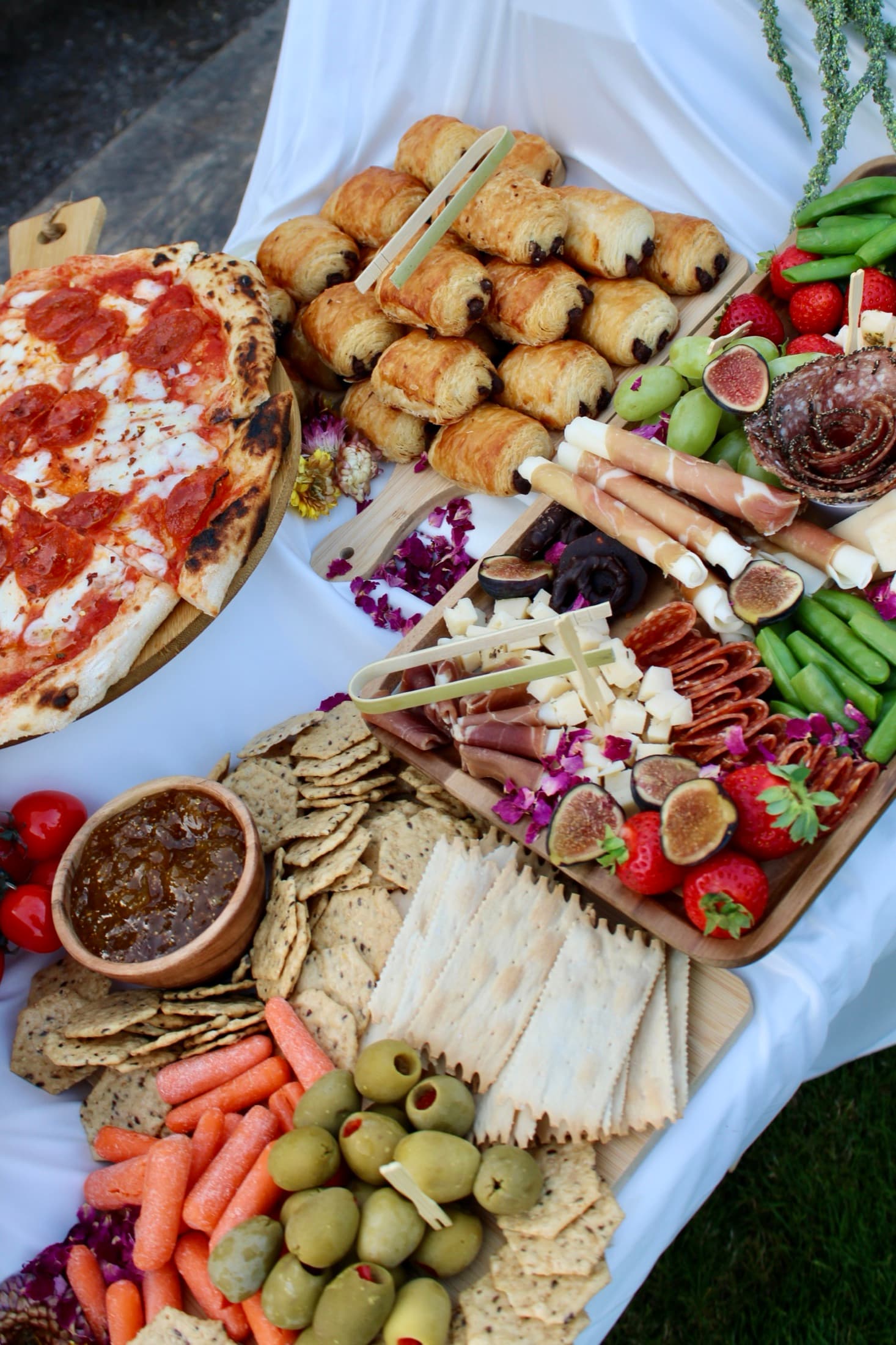 Overhead view of a Forno Via grazing table with pizza, charcuterie, cheeses, fruit, vegetables, and breads