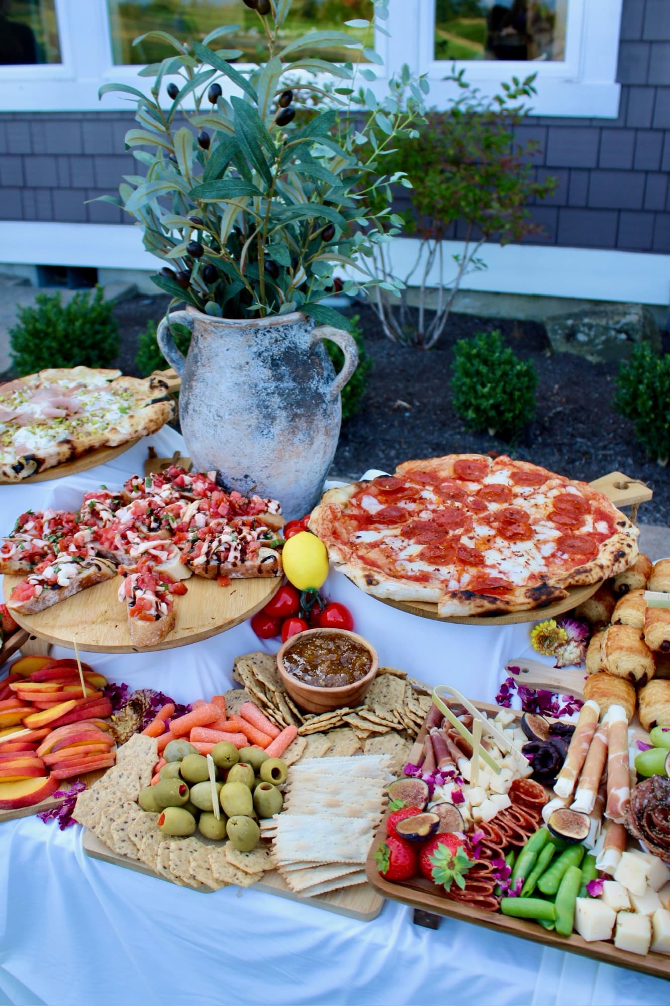 Forno Via pizza and grazing display with bruschetta, charcuterie, fruit and olives.